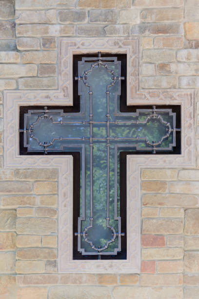 istock glass and metal cross in brick stone wall 1175146112