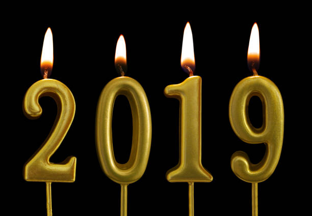 istock Burning golden candles isolated on black background, number 2019 1175146826