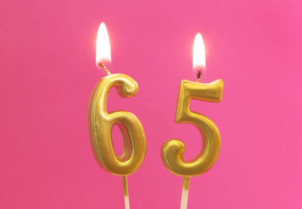 istock Golden birthday candle on pink, number 65 1175146837