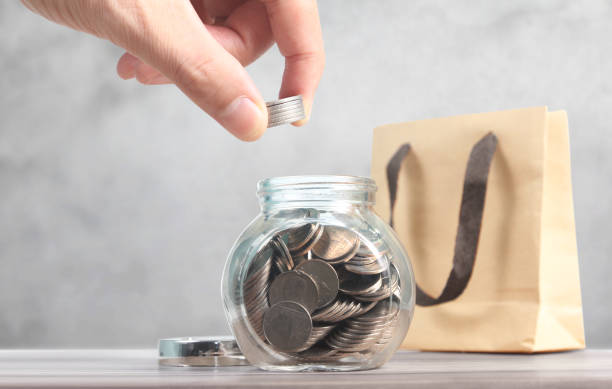 istock Dropping Coins into Glass Jar Labeled Retirement 1175148586