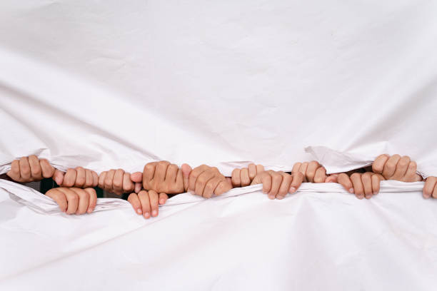 istock Hands helping each other to pull the white paper and small hands 1175153313