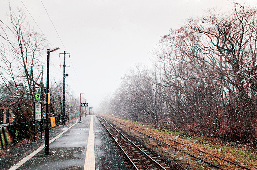 DEC 1, 2018 Hakodate, JAPAN - JR Onuma Koen station empty platform during snow fall in winter foggy atmosphere and beautiful nature scene
