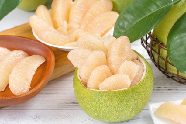 istock Fresh peeled pomelo, pummelo, grapefruit, shaddock on bright wooden table background. Seasonal fruit for Mid-Autumn Festival. 1175156128
