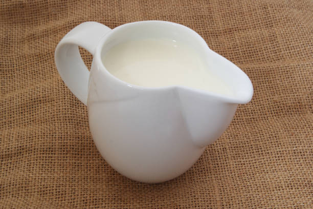 istock Milk in jug on burlap background 1175157146