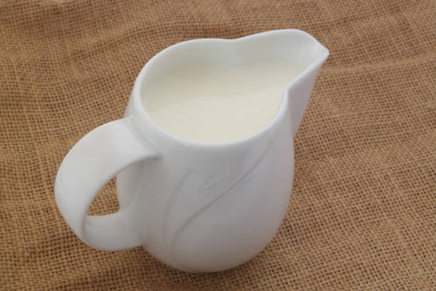 istock Milk in jug on burlap background 1175157162