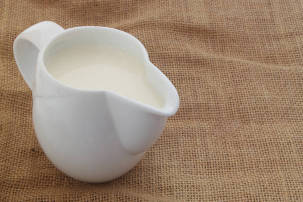 istock Milk in jug on burlap background 1175157170