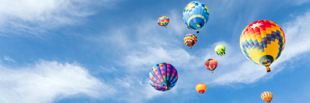 Hot air balloons Multi colored hot air balloons in sunny blue sky ballooning festival stock pictures, royalty-free photos & images