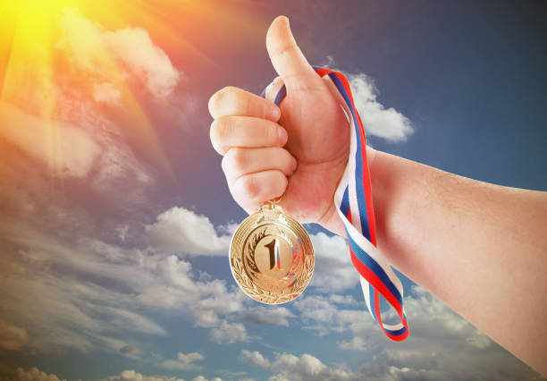 istock Hand holding gold medal on sky background 1175161417