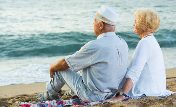 istock Mature man and woman sitting back on towel 1175164630