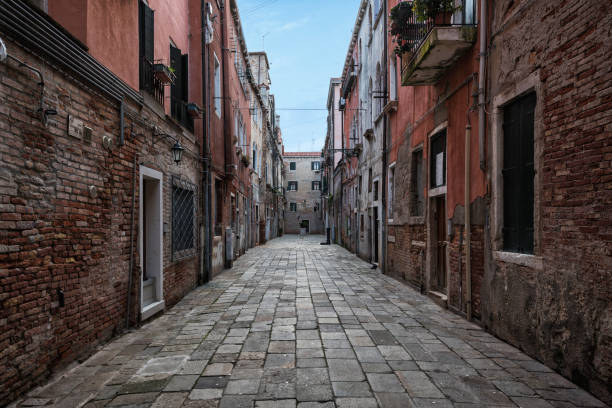 Venice's old town with paved path and old house façade left and right.