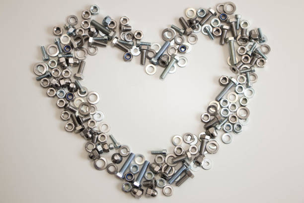 istock A heart lined with a variety of nuts, bolts, screws and washers with empty space inside on a light gray background 1175166418