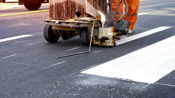 istock Road worker painting crosswalk on asphalt road 1175171066