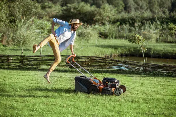 Photo of Man with lawn mower on the backyard