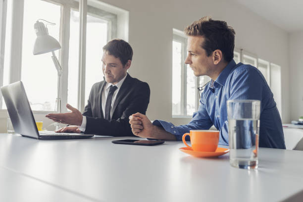 istock Two businessmen sitting at an office desk working together 1175172685