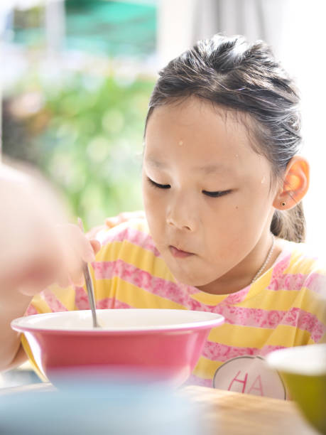 istock Cute Asian girl eats rice soup for breakfast 1175173678