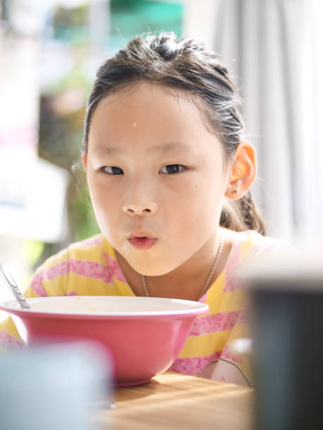 istock Cute Asian girl eats rice soup for breakfast 1175173681