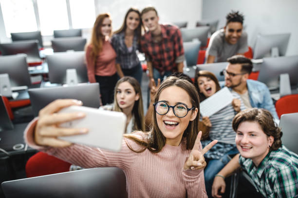 istock Large group of happy students taking a selfie in computer lab. 1175173979
