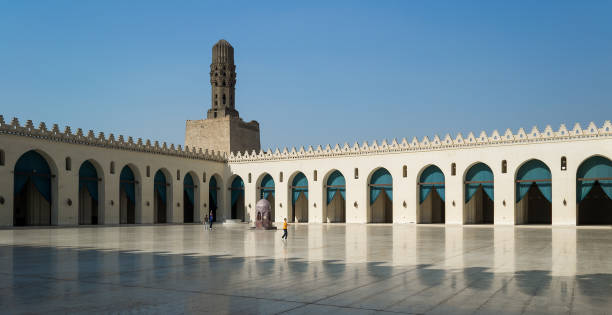 cortile della storica moschea pubblica di al hakim conosciuta come la moschea illuminata con minareto, cairo - courtyard arch arabic style cairo foto e immagini stock