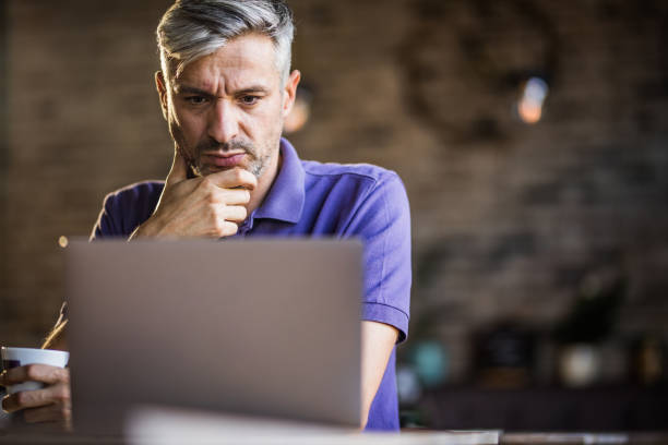 istock Pensive businessman reading an e-mail on laptop in a cafe. 1175177391