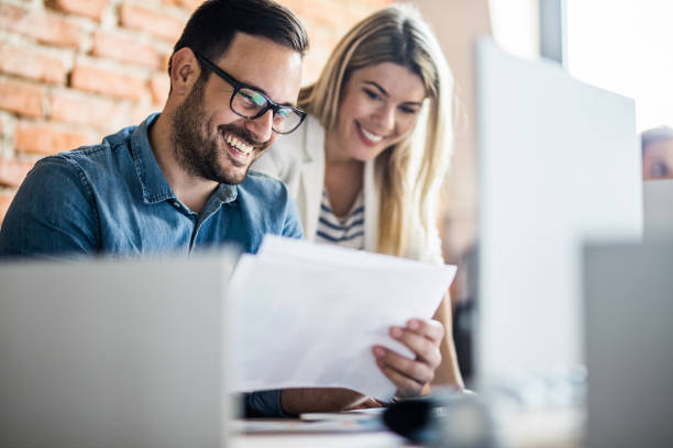 istock Happy business colleagues reading documents in the office. 1175180427