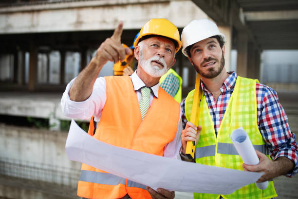 istock Confident team of architects and engineers working together on construction site 1175181363