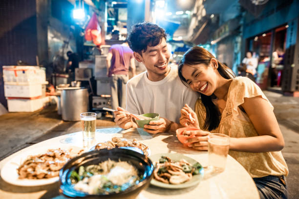 Asian couple enjoying street food in Hong Kong stock photo