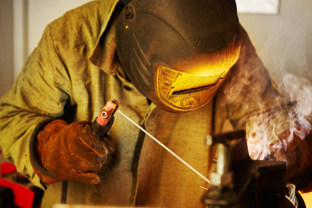 istock Male in face mask welds with welding 1175185655