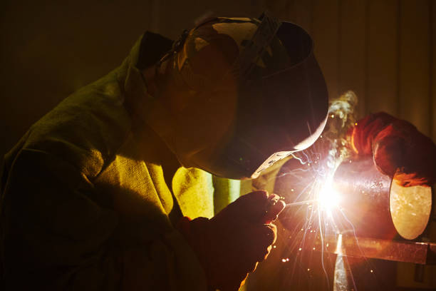 istock Male in face mask welds with welding 1175186180