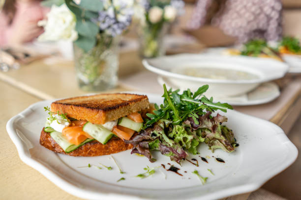 francuski tosty brioche, kanapka z łososiem i ogórkiem. lekkie śniadanie rano, świeże ciepłe wypieki i aromatyczna kawa cappuccino na stole w restauracji - french toast toast butter breakfast zdjęcia i obrazy z banku zdjęć