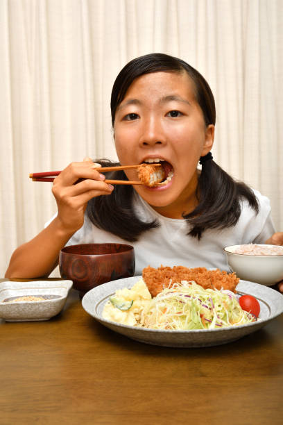 istock Japanese girl enjoys having dinner 1175196826