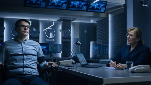 Female Special Agent Conducts Lie Detector Test on a Young Suspect. Corporate Spy Undergoes Polygraph Test, Expert Examiner Questions Accused in Interrogation Room. Computer Measures Reactions. la agente especial femenina lleva a cabo una prueba de detector de mentiras sobre un joven sospechoso. el spy corporativo se somete a una prueba de polígrafo, preguntas del examinador experto acusados en la sala de interrogatorios. reacciones de medidas i