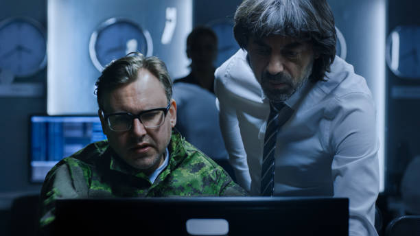 istock Government Chief of Cyber Security Has Problem Solving Discussion with Military Officer who Works on Computer. Specialists Working on Computers in System Control Room. 1175197191