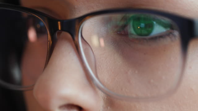 Close up of woman eyes with reading glasses while working