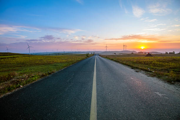 istock Asphalt road and wind turbines 1175199015