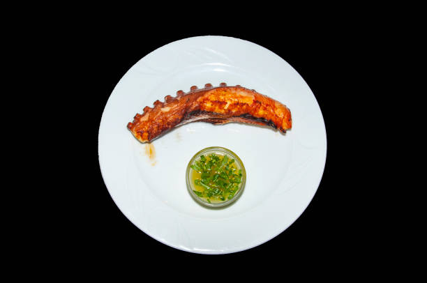 istock Grilled octopus in plate on black background 1175199865