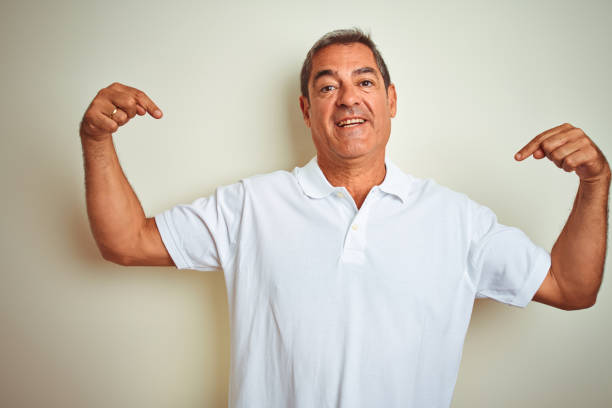 istock Handsome middle age man wearing polo standing over isolated white background looking confident with smile on face, pointing oneself with fingers proud and happy. 1175200433
