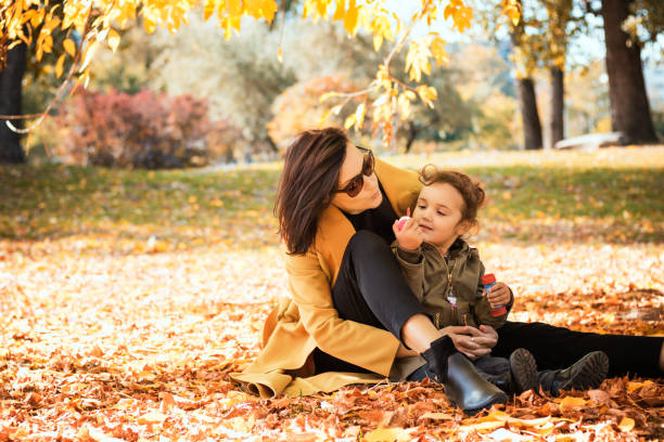 istock Mother and daughter blowing bubbles in autumn day. 1175201373