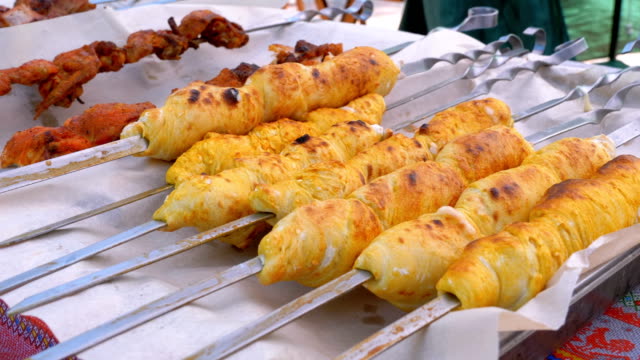 Cooked Cheese Rolls on the Grill on Skew Lie on the Window of a Street Shop