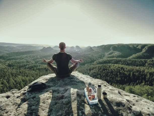 Climber man sit on rock, prepare for eating snack during rest stock photo