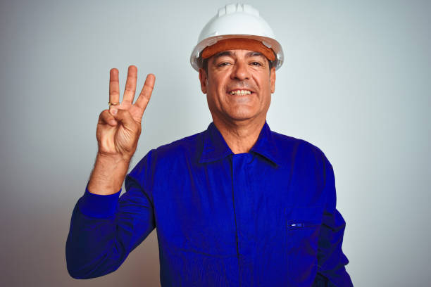 istock Handsome middle age worker man wearing uniform and helmet over isolated white background showing and pointing up with fingers number three while smiling confident and happy. 1175204481