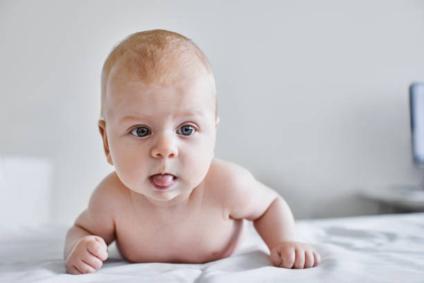 Close-up of cute shirtless baby girl on bed Close-up of cute shirtless baby girl. Female toddler is on hospital bed. She is in medical clinic. half dressed girls pictures stock pictures, royalty-free photos & images
