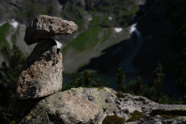 istock Stone cairn on the mountains background, three stones tower 1175210714