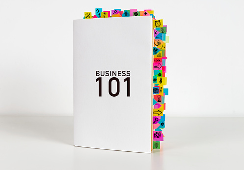 Business 101 book and sticky reminders on the white background. Elementary book.