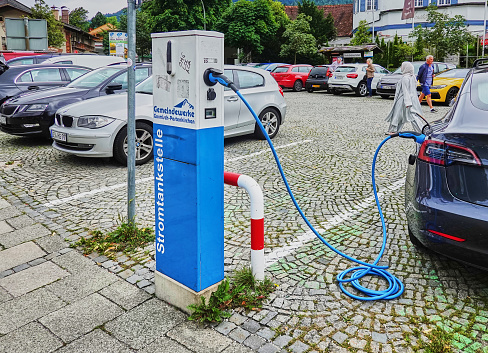 Garmisch-Parenkirchen, Germany, August 10., 2018: Charging station with connected electric car on a parking lot
