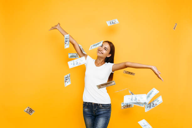 istock Happy excited woman throws money on yellow background 1175223802