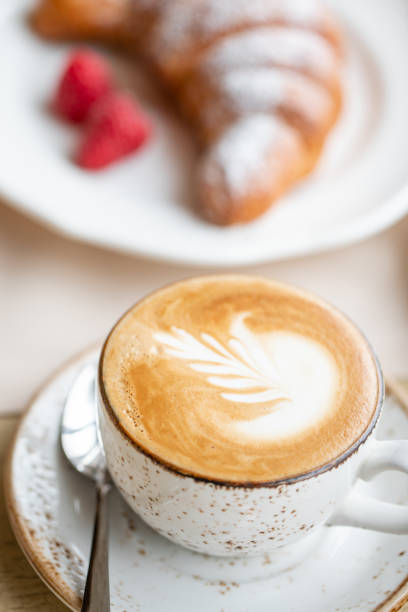 istock Coffee cappuccino with croissant on white plate in restaurant. Light morning Breakfast, fresh warm pastries and raspberries 1175226444