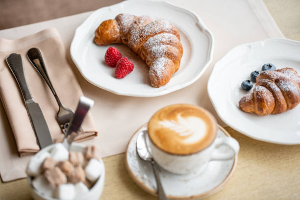 istock Coffee cappuccino with two croissant on white plate in restaurant. Light morning Breakfast, fresh warm pastries and raspberries 1175226534