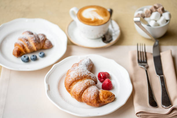 istock Coffee cappuccino with two croissant on white plate in restaurant. Light morning Breakfast, fresh warm pastries and raspberries 1175226578