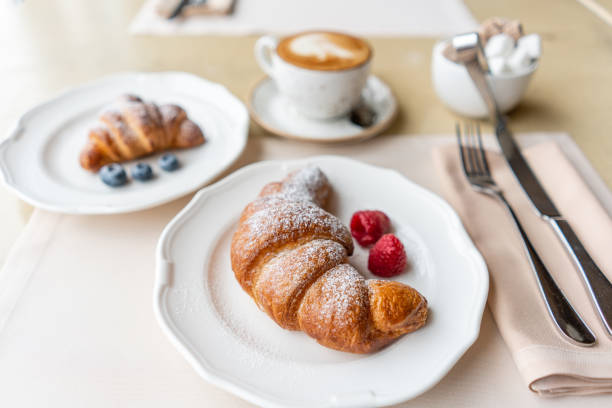 istock Coffee cappuccino with two croissant on white plate in restaurant. Light morning Breakfast, fresh warm pastries and raspberries 1175226647