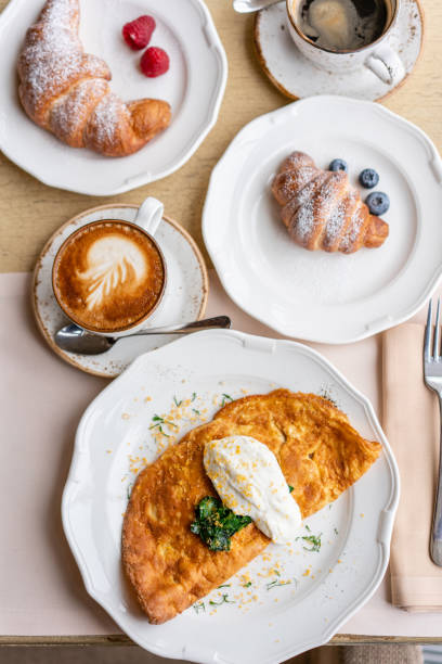 istock Breakfast. Frittata - italian omelet. Omelette with tomatoes, avocado, spinach and soft cheese. Croissants, coffee and other dishes on the table in the restaurant 1175227886